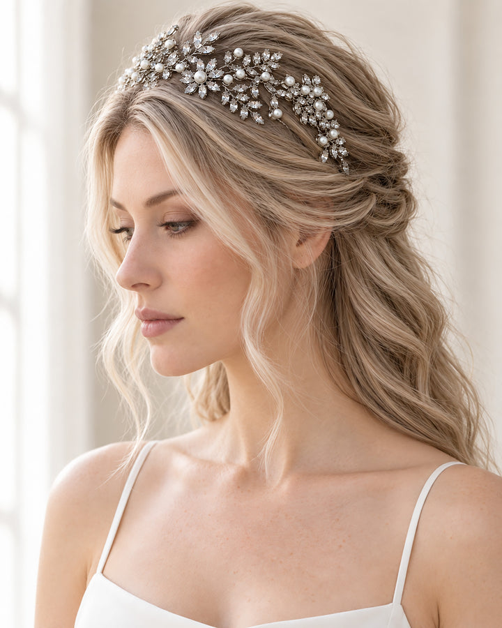 Liora silver bridal headband with rhinestone leaves and ivory pearls worn with soft half-up wedding waves