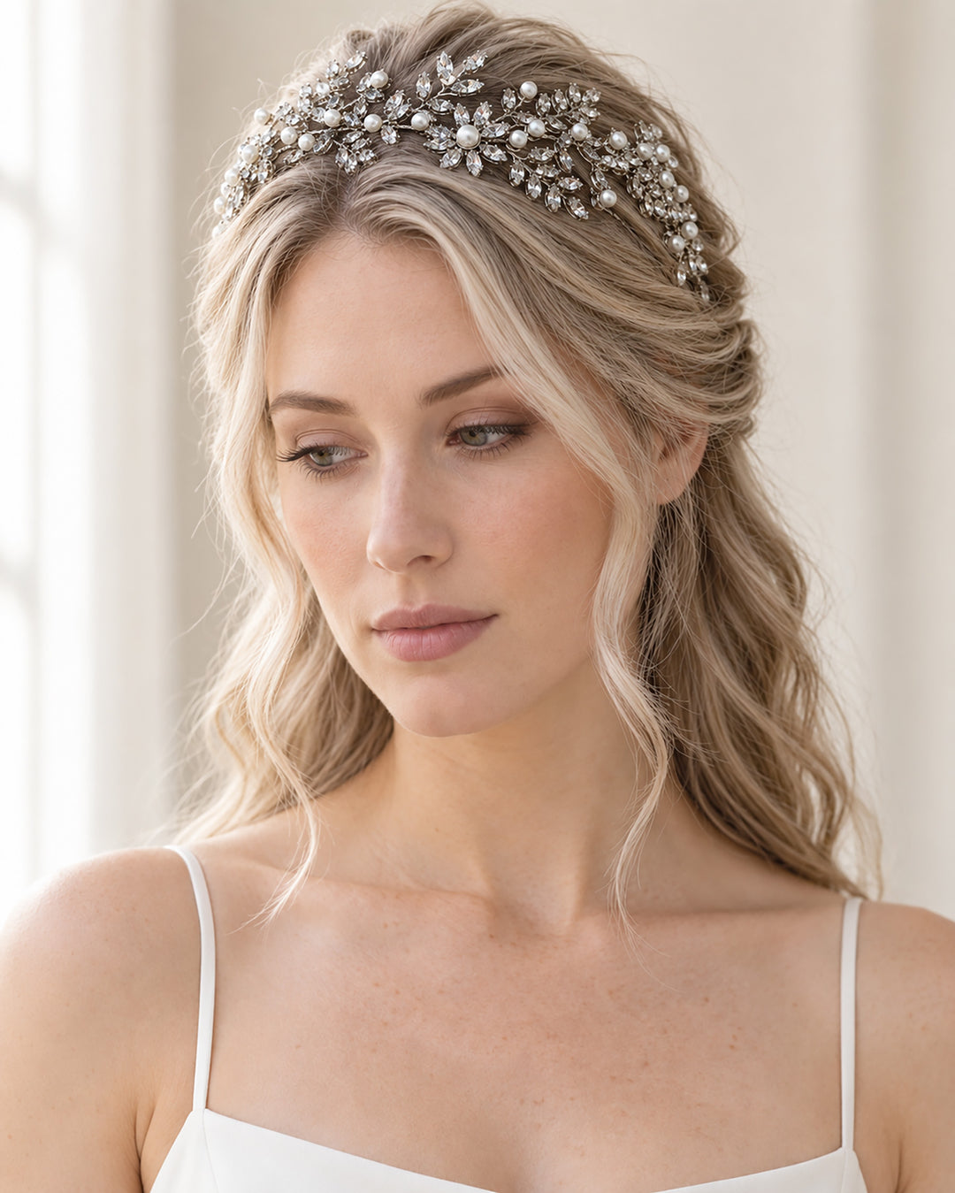 Front view of a bride wearing the Liora headband across her crown with her hair half up