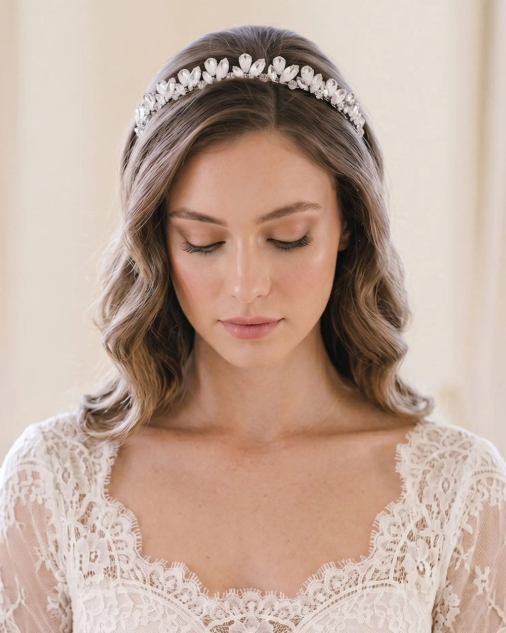 Bride with soft waves and a lace gown wearing a slim silver rhinestone headband across her crown