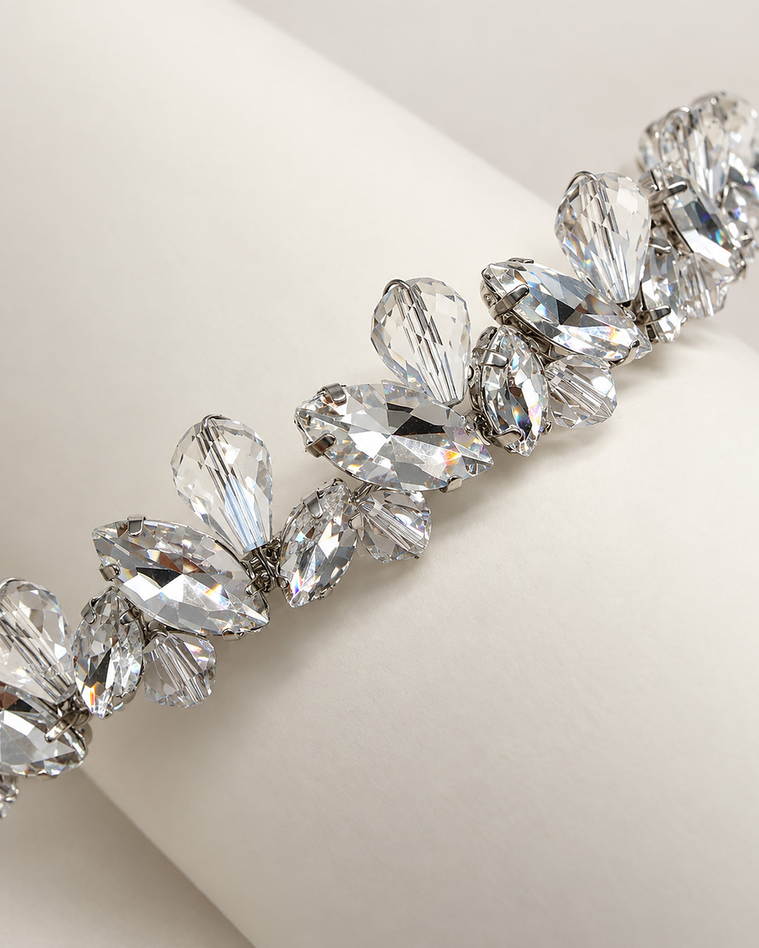Close-up of marquise rhinestones and faceted crystal teardrops on a slim silver wedding headband
