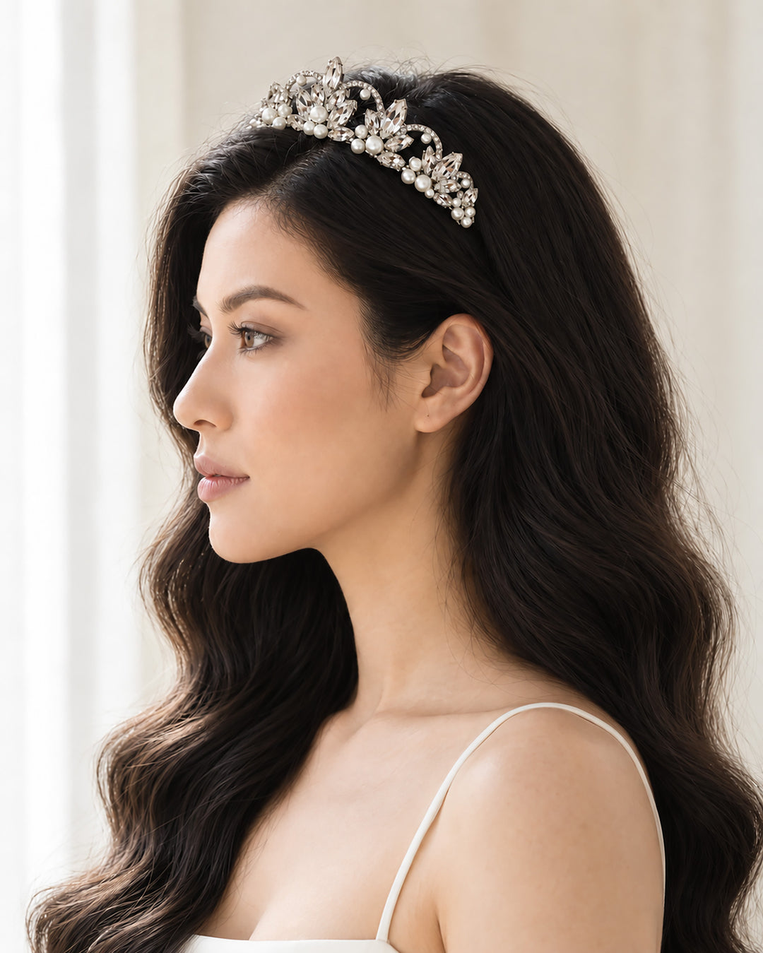 Side profile of a bride wearing a silver pearl and rhinestone crown tiara