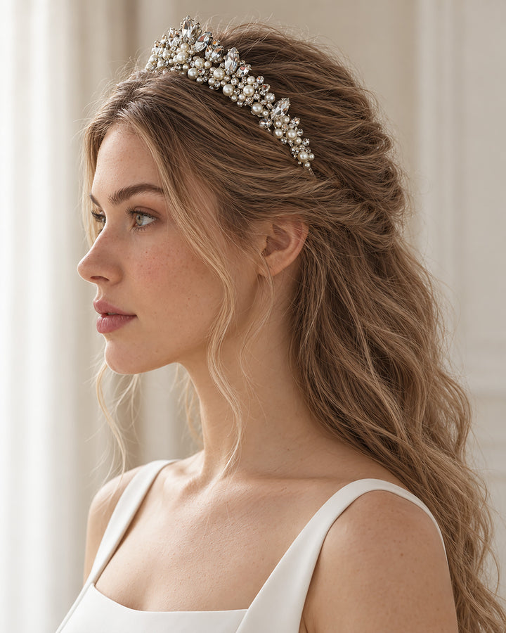 Side profile of a bride wearing a silver pearl crystal tiara with soft waves