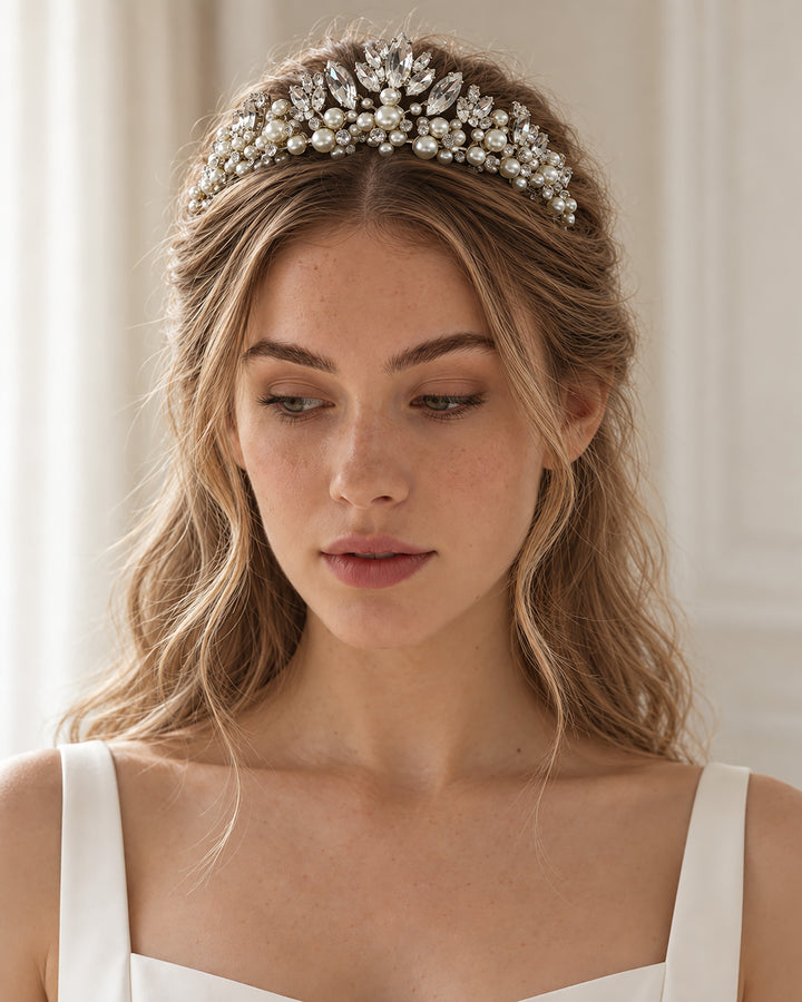 Bride with loose waves wearing a silver pearl and crystal tiara with a center peak