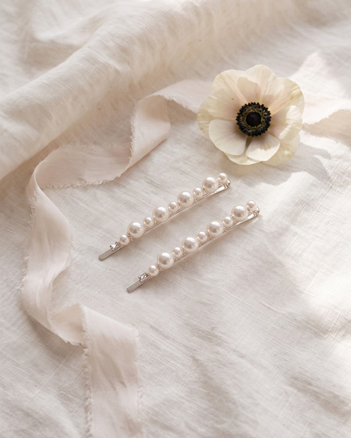 Two pearl bobby pins on ivory linen with silk ribbon and a white anemone