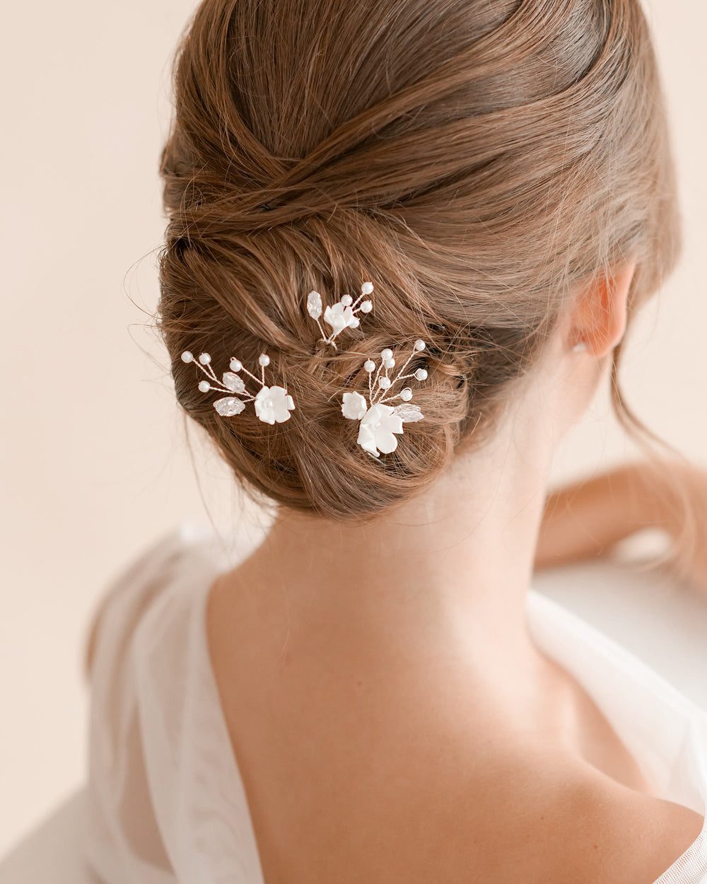 Braided updo decorated with small fabric floral hair pins