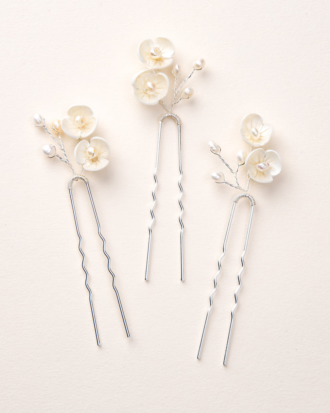 Three silver hairpins with floral decorations 
