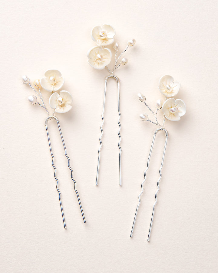 Three silver hairpins with floral decorations 