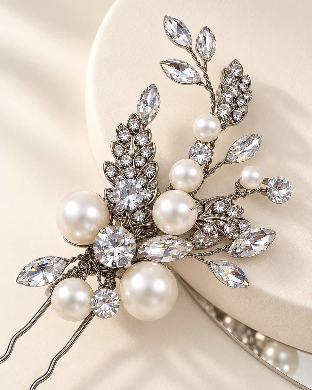 Close-up of a wedding hair pin showing leaf clusters and layered pearl accents