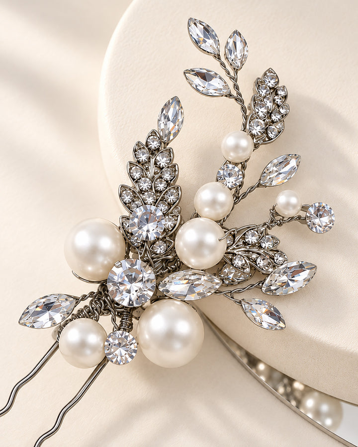 Close-up of a wedding hair pin showing leaf clusters and layered pearl accents
