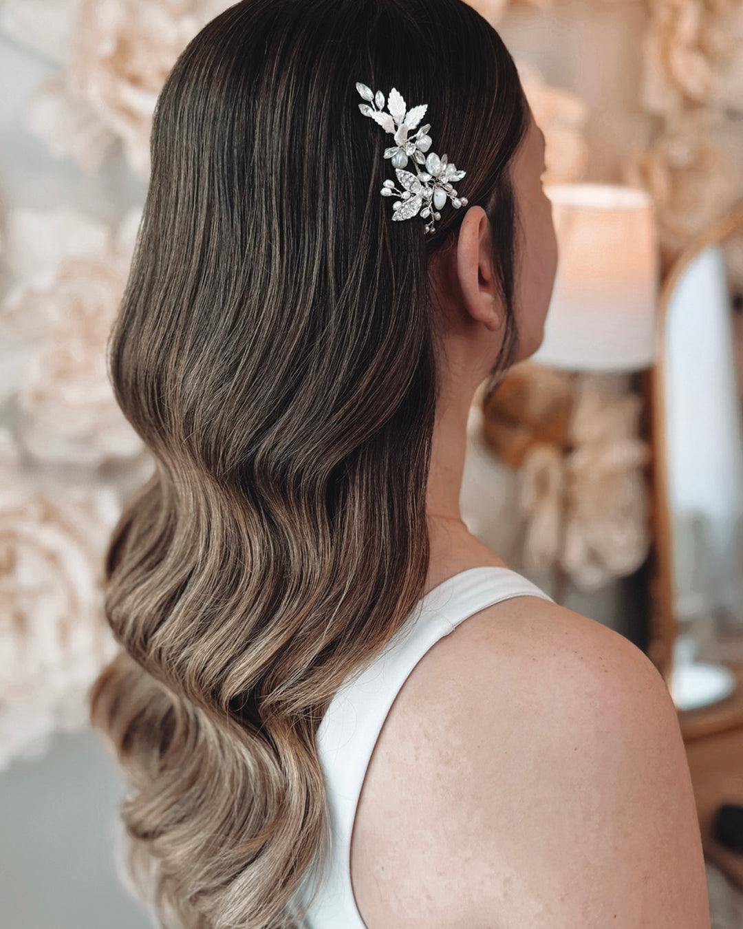 Bride wearing pearl crystal rhinestone flower jeweled leaf hair pin in hair down with loose curls for wedding hairstyle