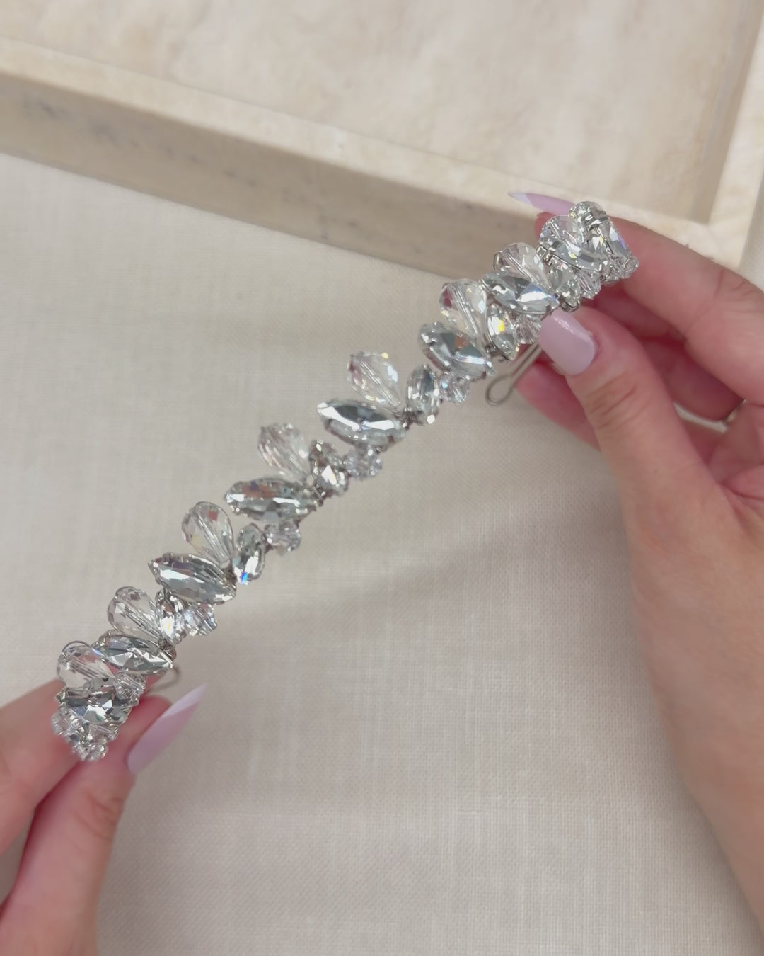 Video of a slim hand-wired silver bridal headband with marquise rhinestones and faceted crystal teardrops