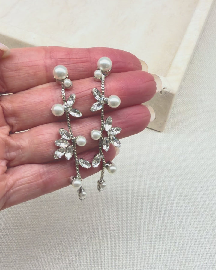 Hand holding the Katrina wedding earrings to show the pearls and marquise cubic zirconia moving on the chain