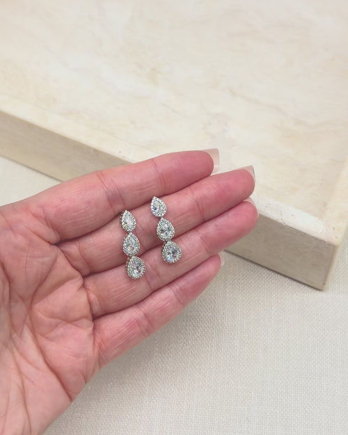 Video of the Willa pear halo drop earrings showing the sparkle of all three tiers in motion