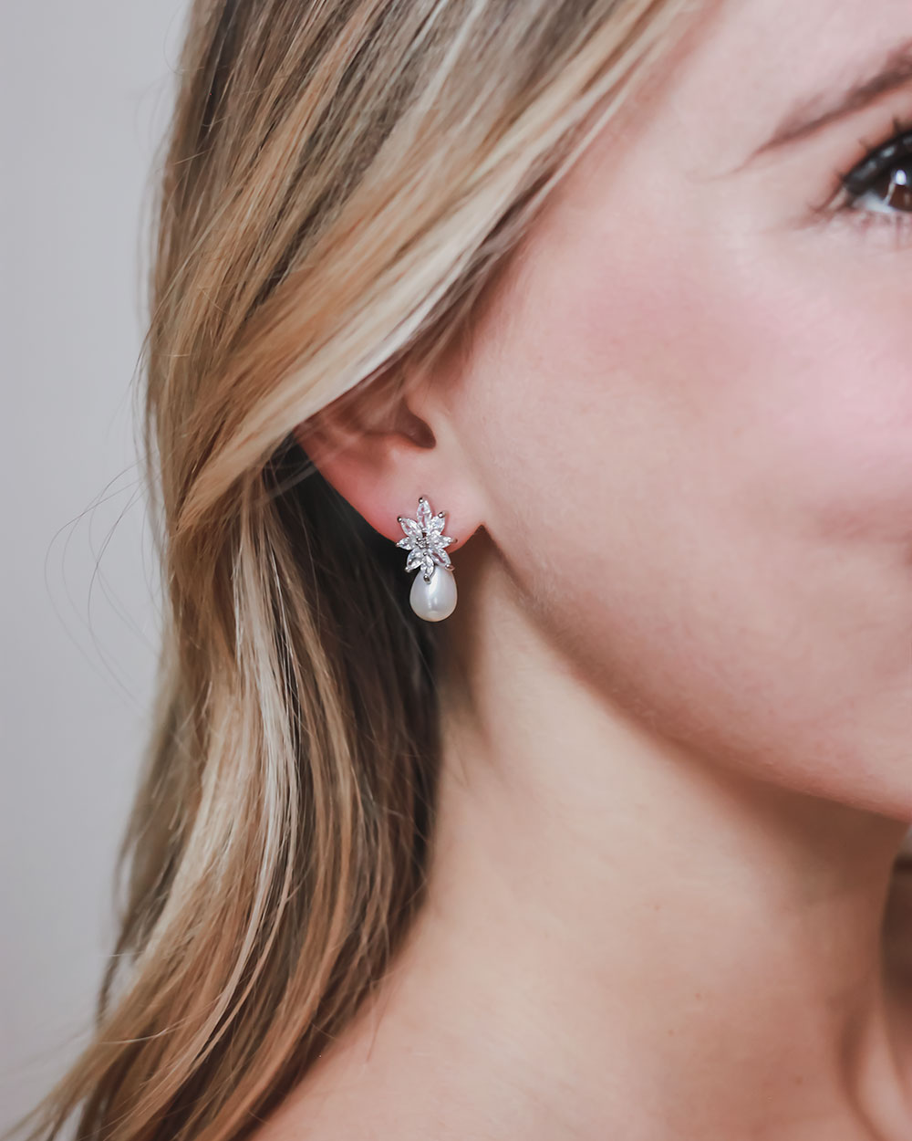 Side profile of the Elsie wedding earrings worn with long hair tucked behind the ear